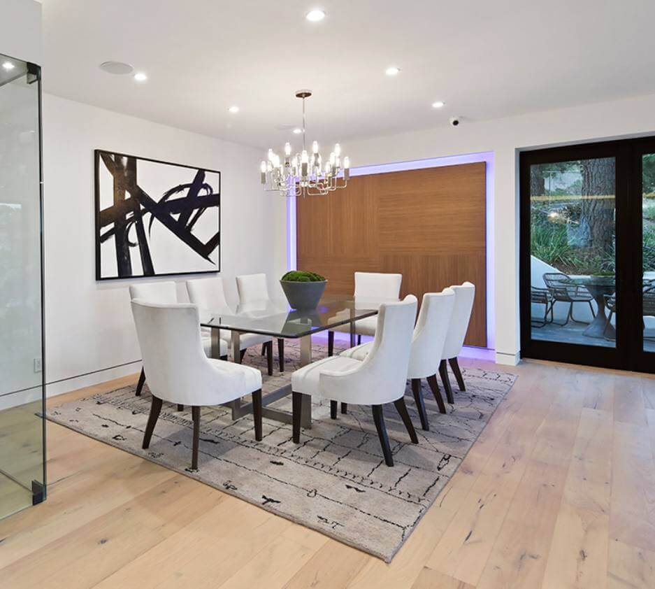 Dining room with white chairs and wood floors
