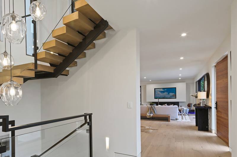 Stairs leading upward with living room in the distance