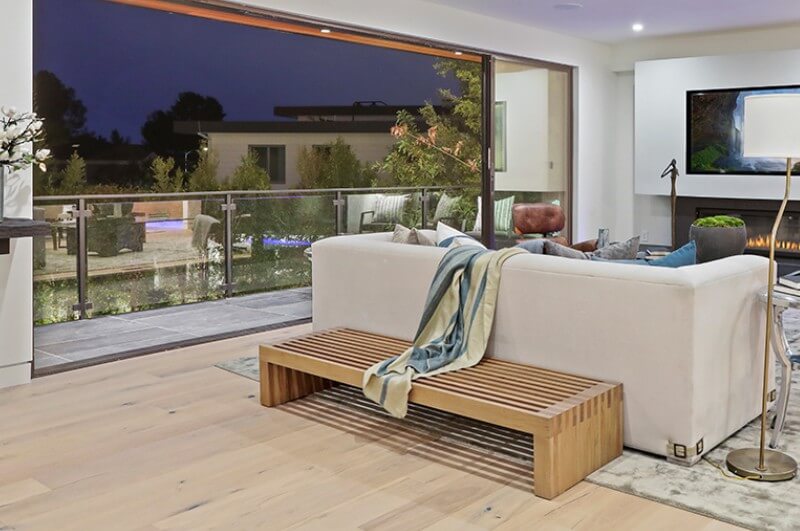 Room with glass wall, wood floor, and wood bench